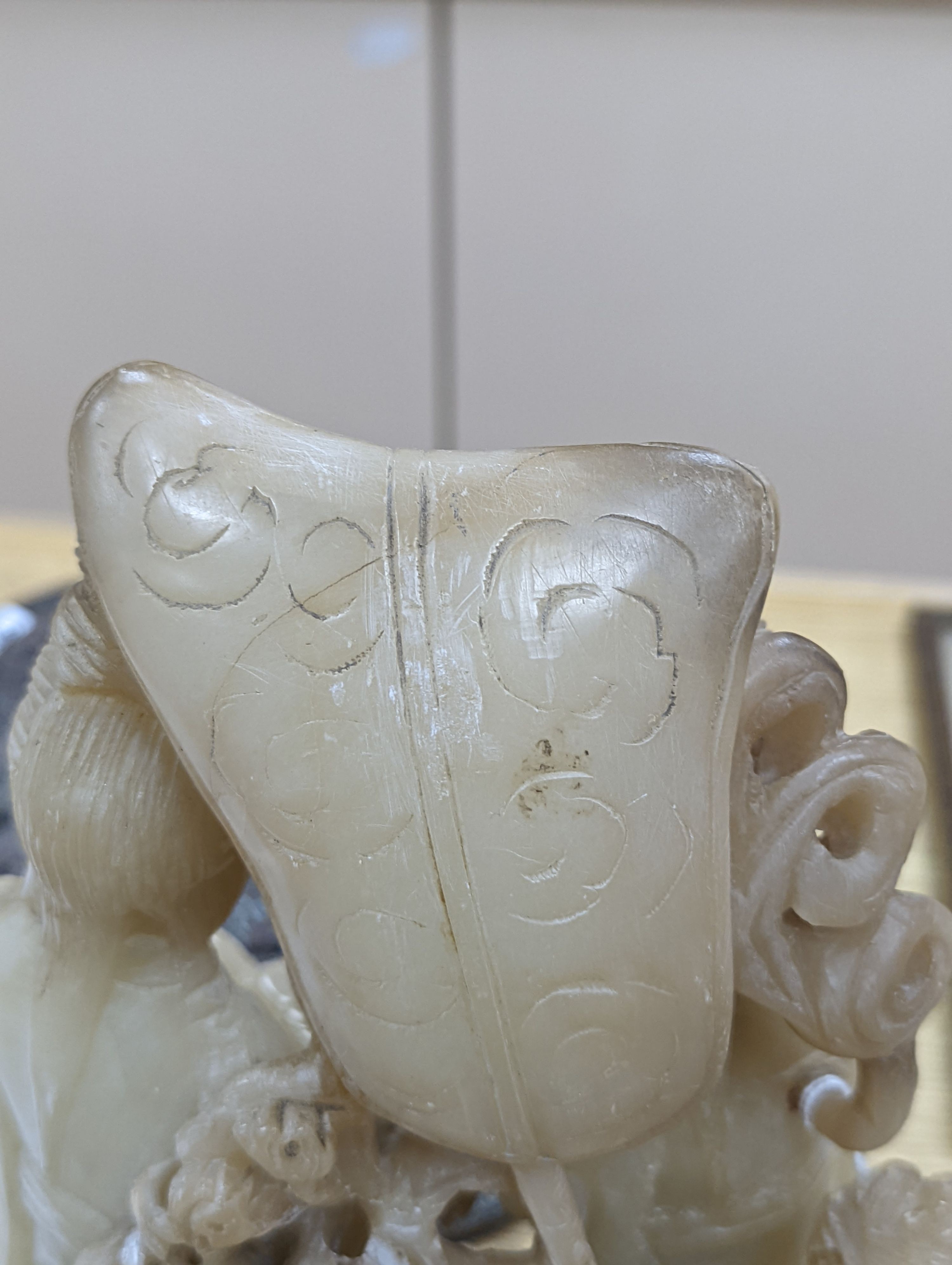 A Chinese soapstone carving of two ladies, wood stand, early 20th century, 36 cms high.